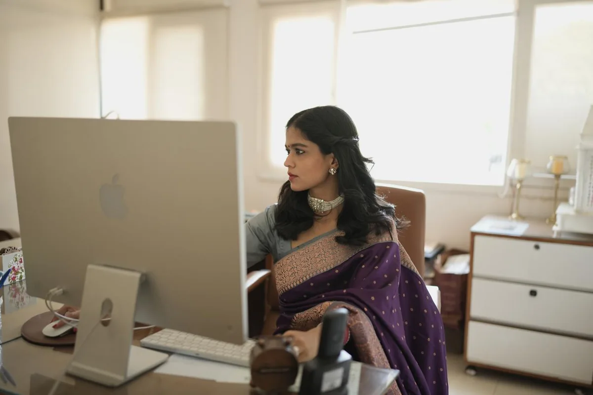 Pranvika Bedi at the Edvantage mentoring desk with the toppers wall behind her